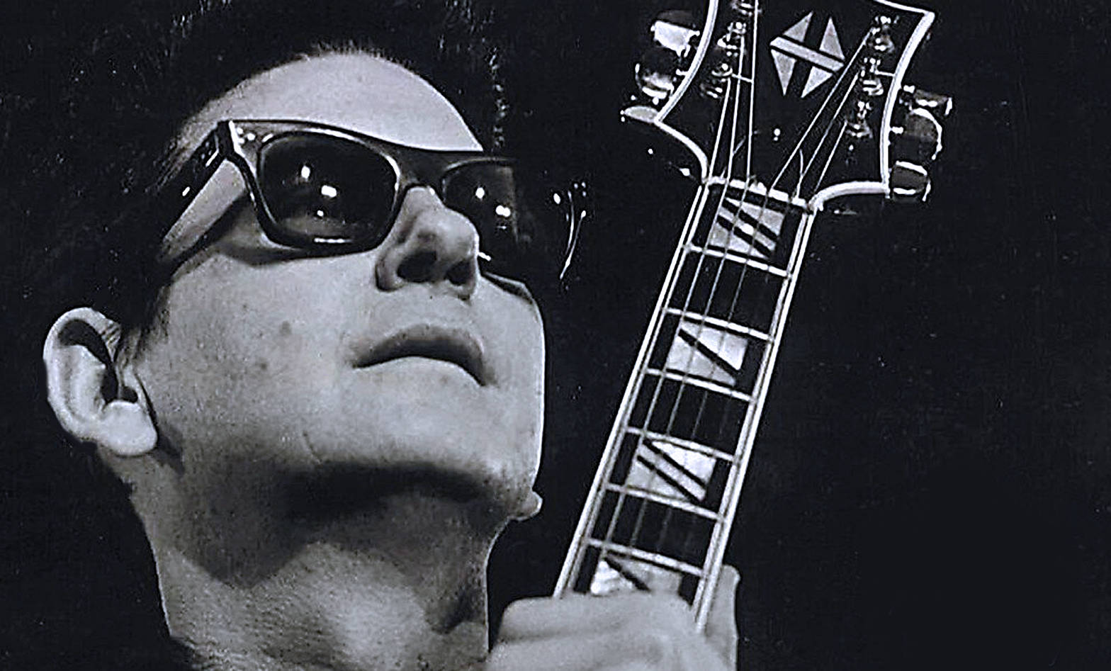 Legendary Musician Roy Orbison Strumming His Guitar Wallpaper