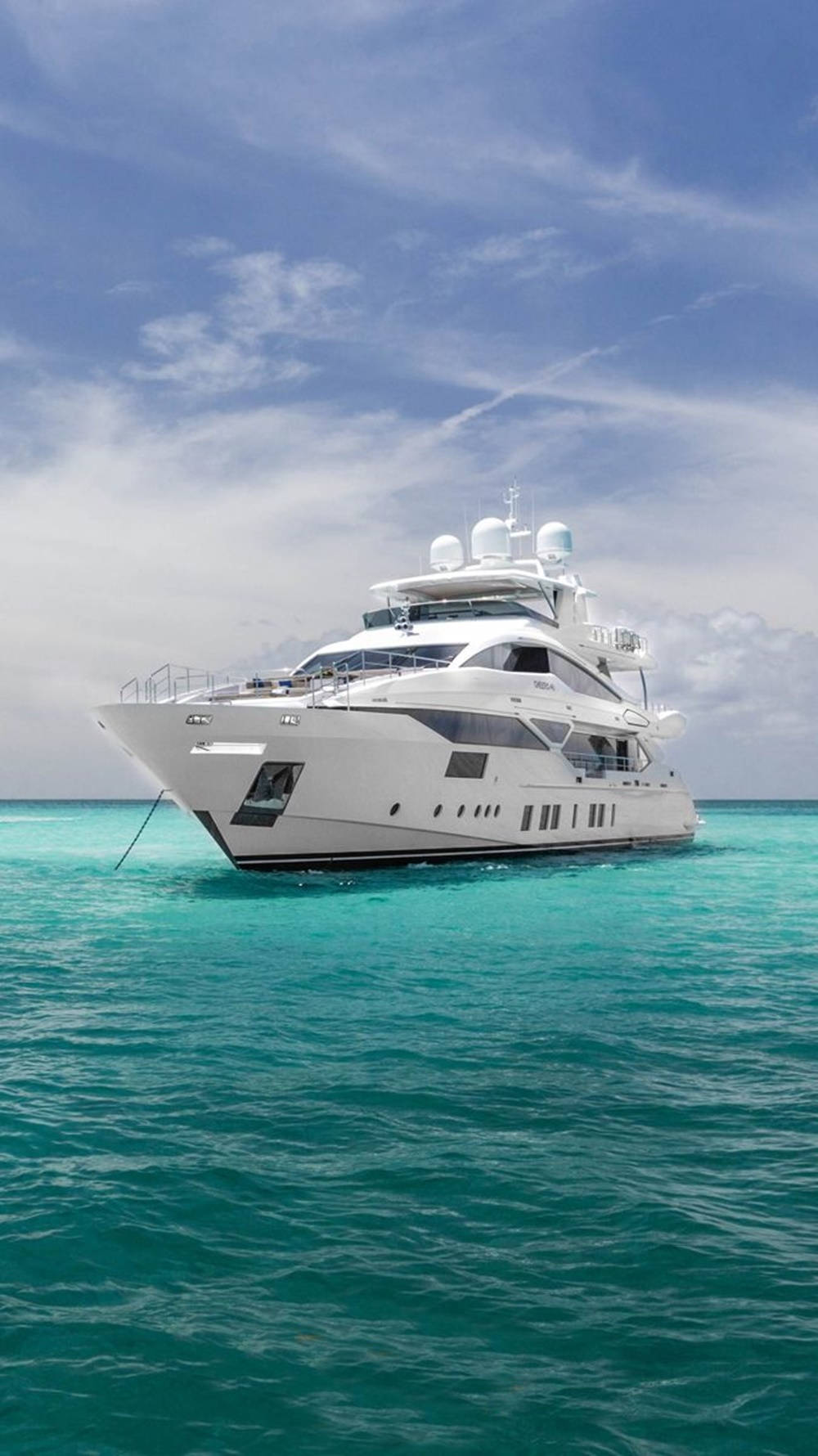 Majestic Yacht Sailing Under A Cloudy Blue Sky Wallpaper