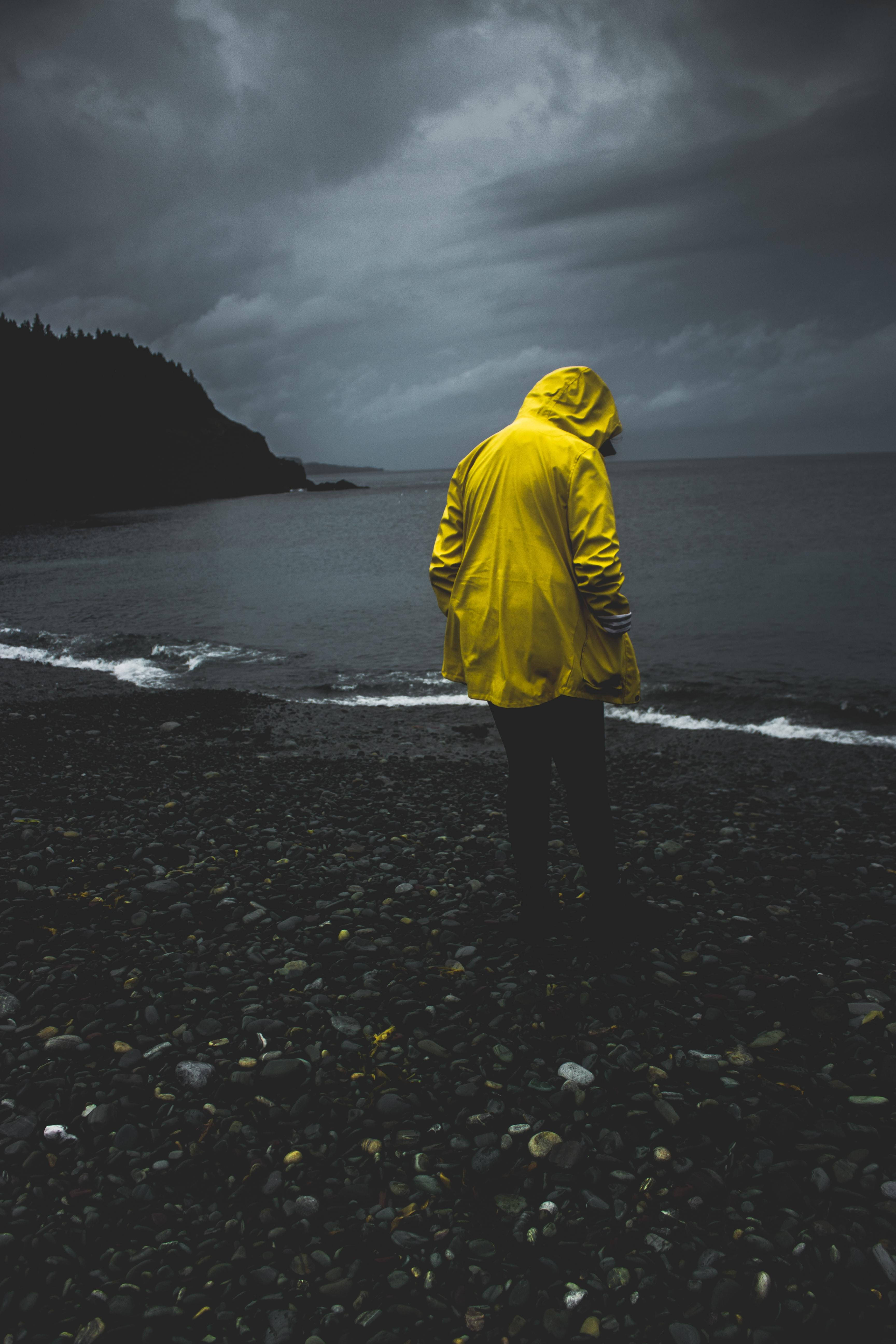 Man On Rocky Seashore Alone Phone Wallpaper