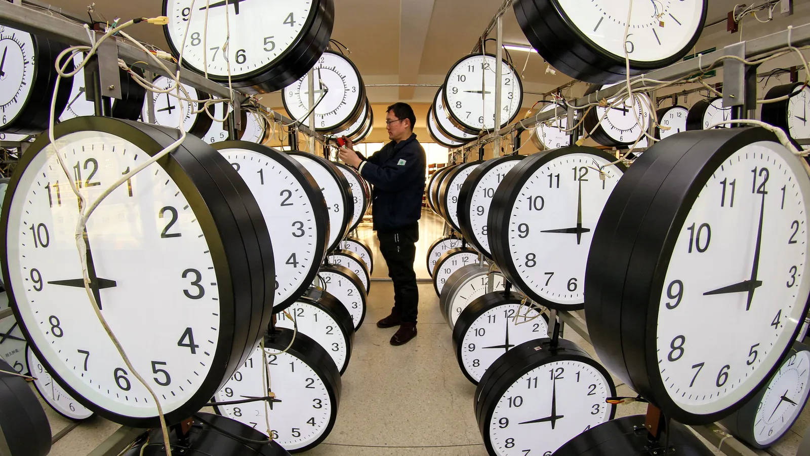Man Synchronizing Various Clocks Wallpaper