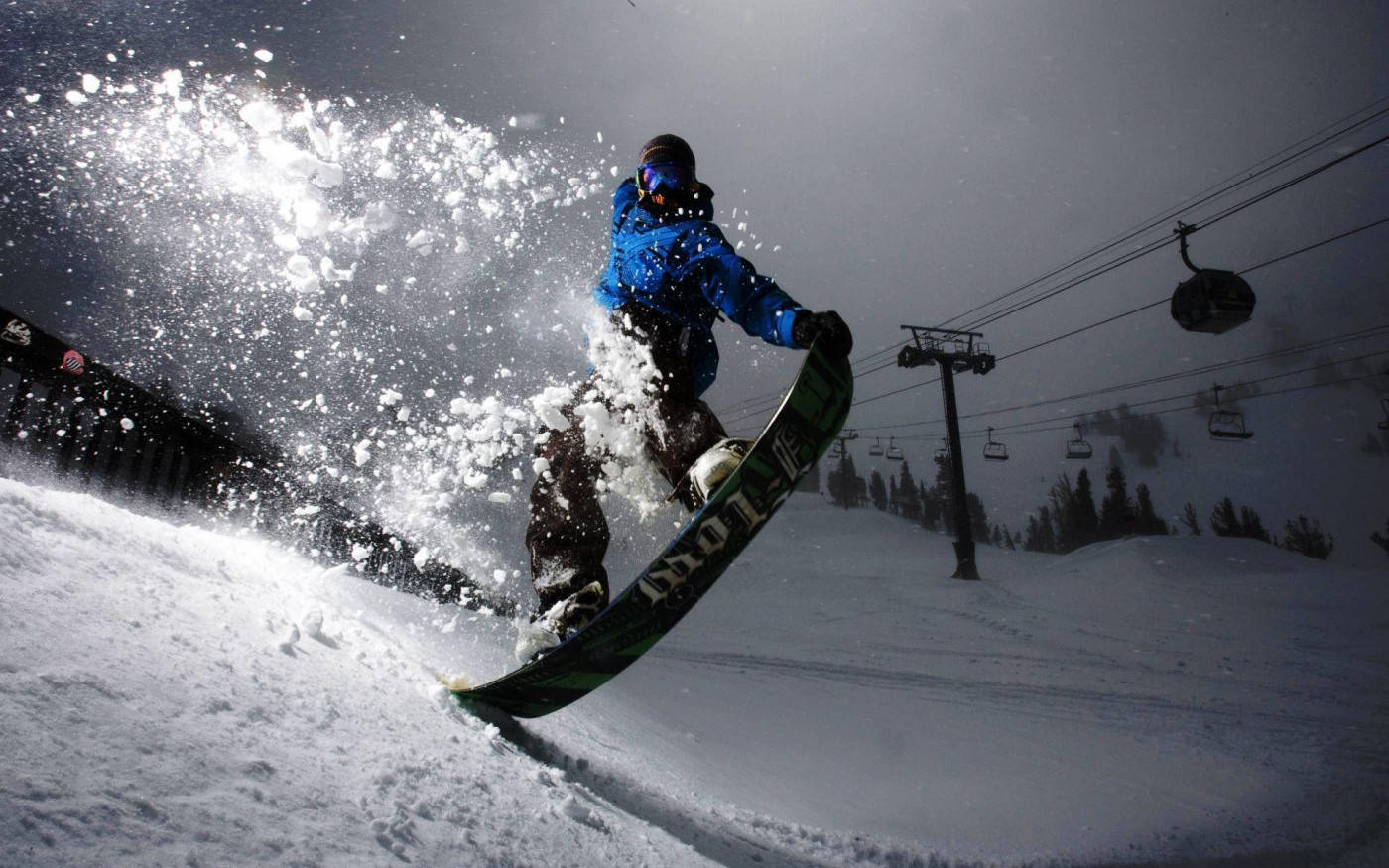 Man With Snowboard And Cable Cars Behind Him Wallpaper