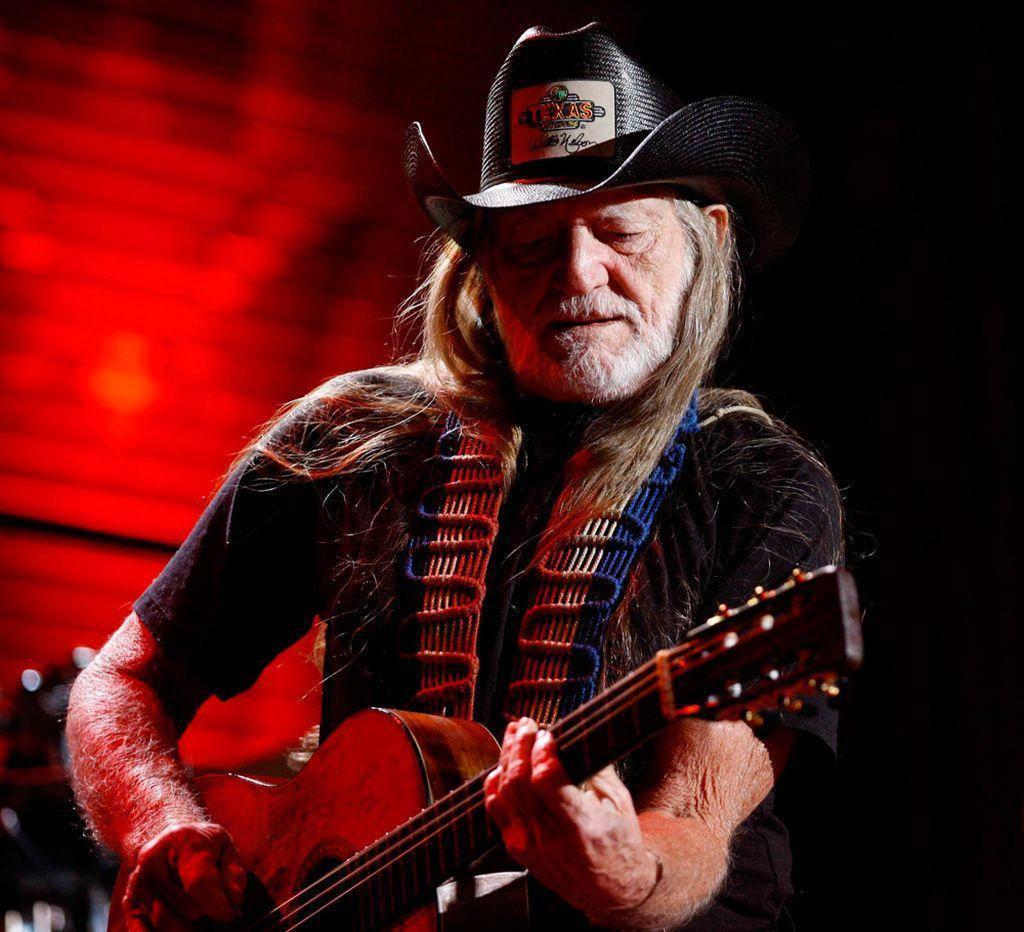 Musician Willie Nelson Playing Guitar Wallpaper