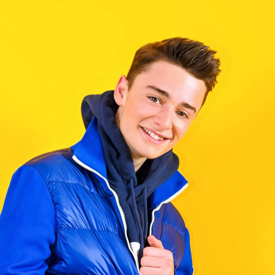 Noah Schnapp Posing Against Bright Yellow Backdrop Wallpaper