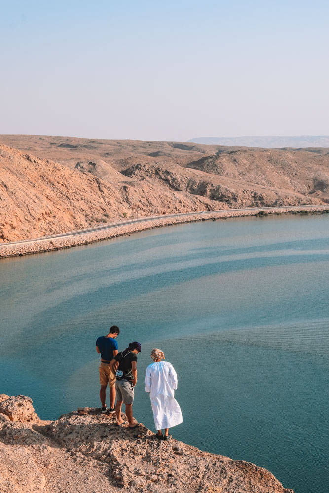 Oman Three Men On Cliff Wallpaper