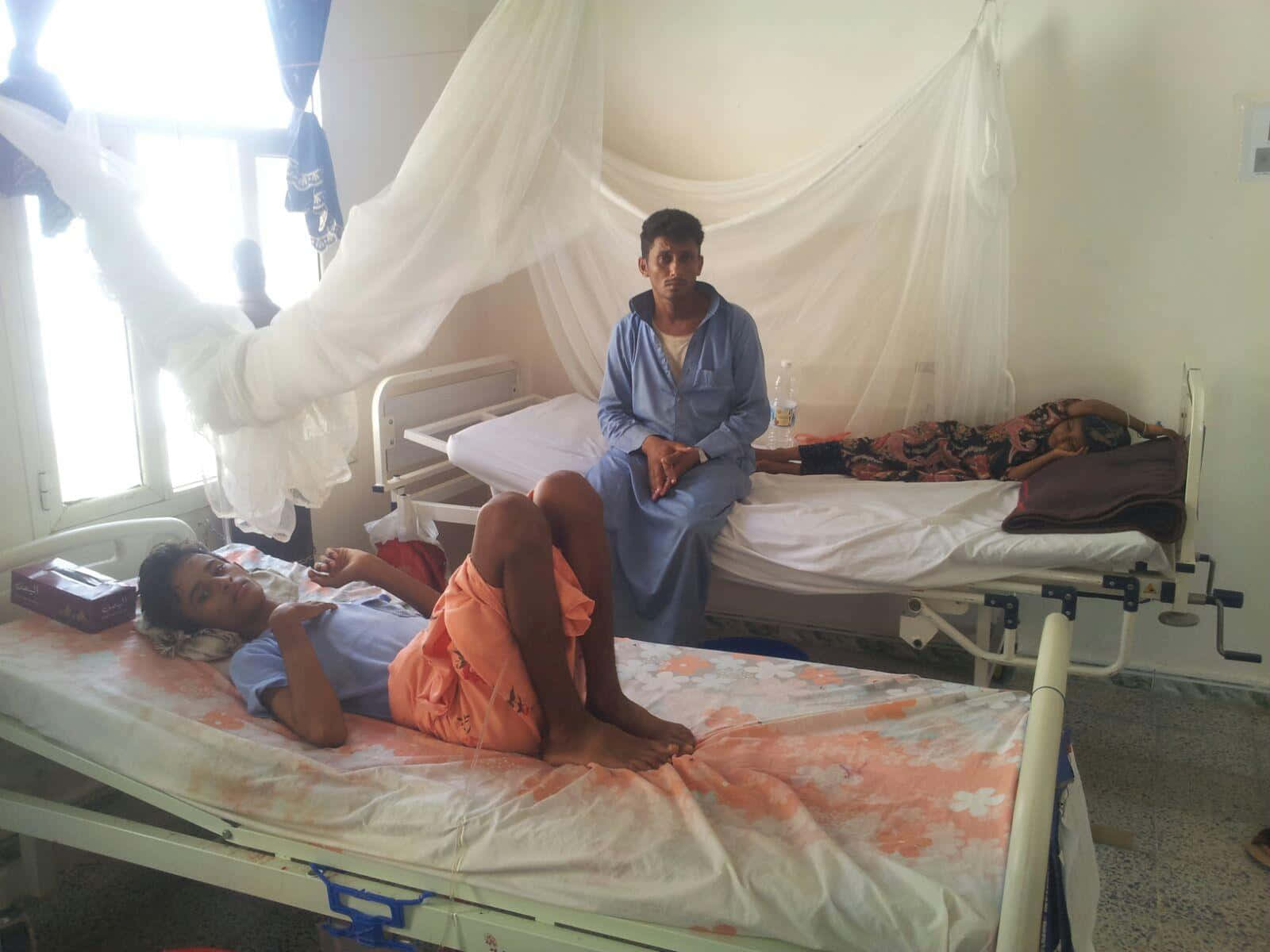 Patient Relaxing On Public Hospital Bed Wallpaper