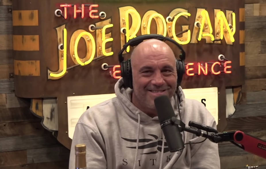 Podcast Host Joe Rogan With Show Logo Wallpaper