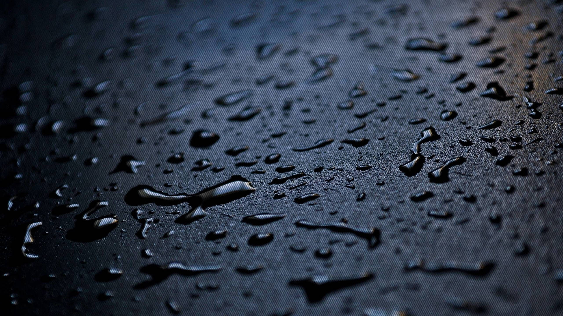 Raindrops And Water Splashes On A Black Surface Wallpaper