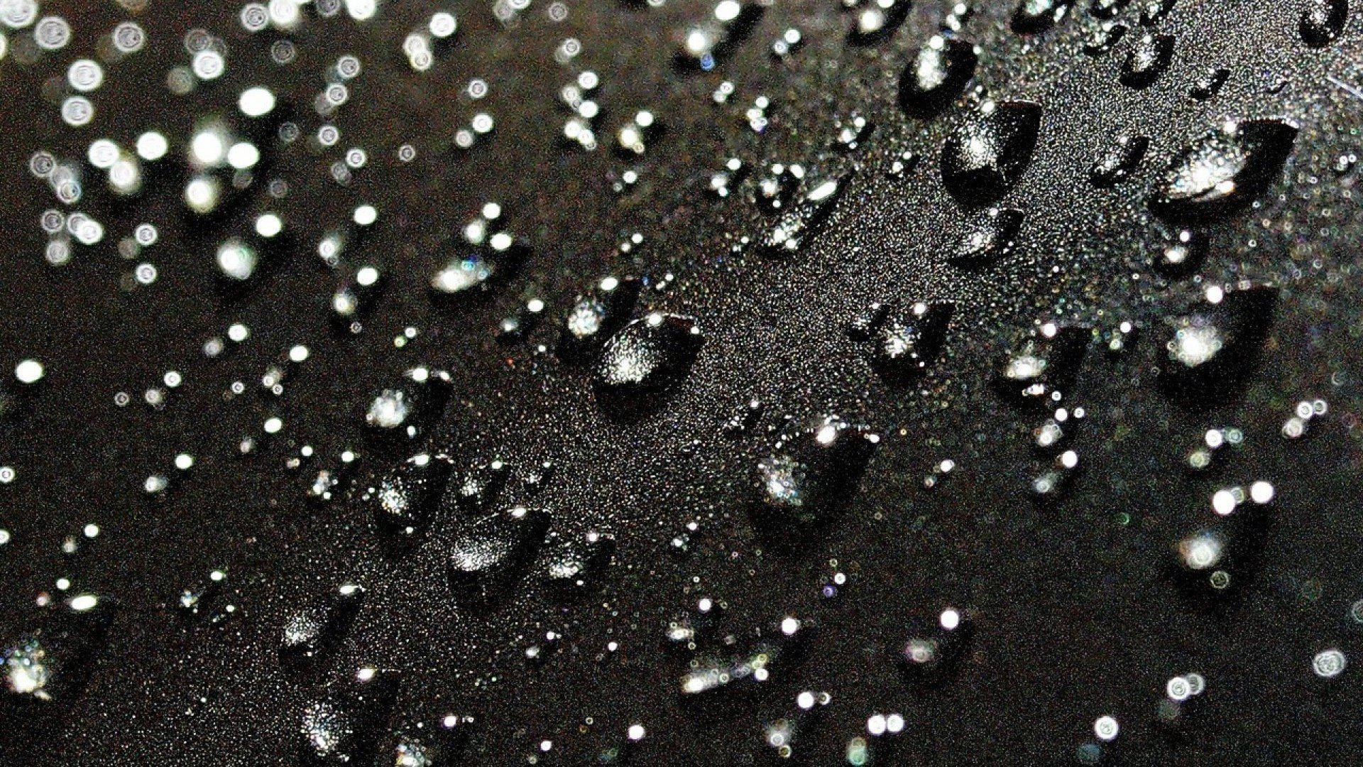 Raindrops Falling On A Deep Black Surface Wallpaper