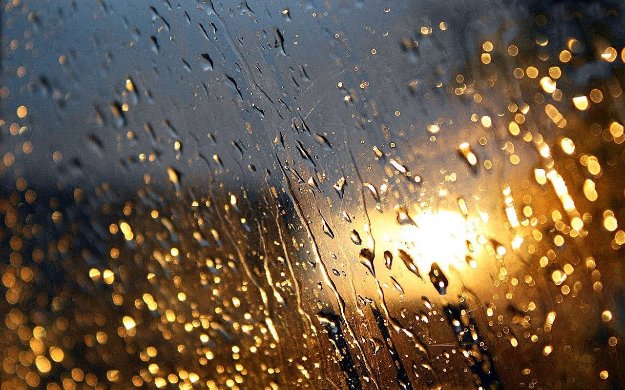 Raindrops On Glass With Light Reflection Wallpaper