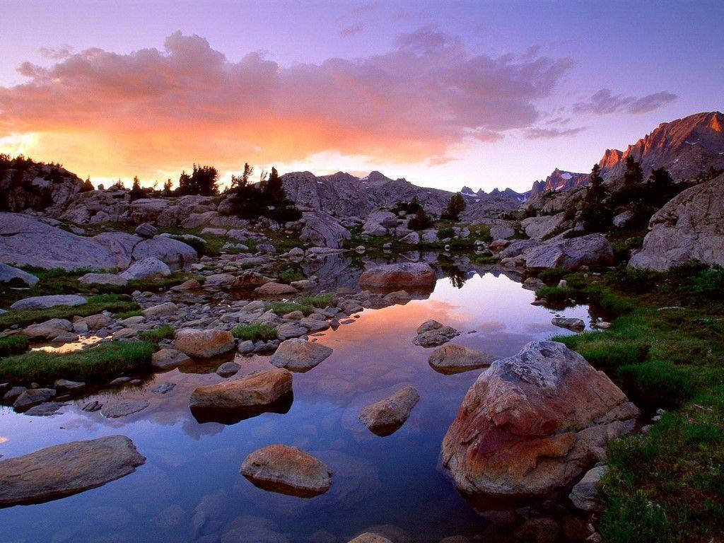 Rocky Mountain With Boulders Scattered Across The River Wallpaper