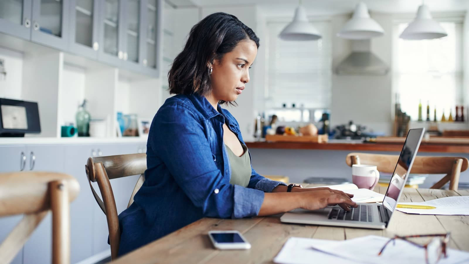 Serious Secretary Working With Laptop Wallpaper