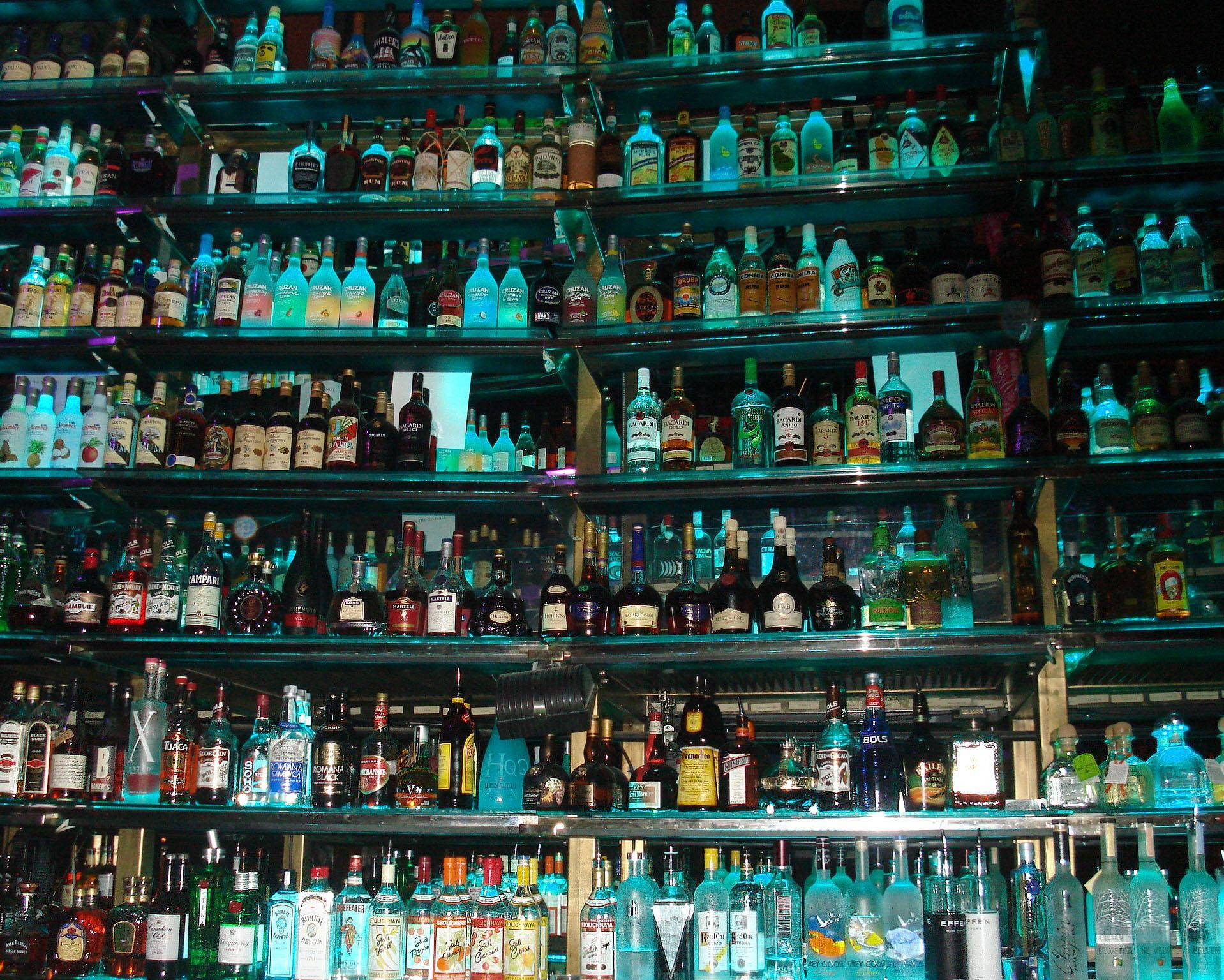 Shelf Of Alcohol With Tanqueray Gin On Bottom Left Wallpaper