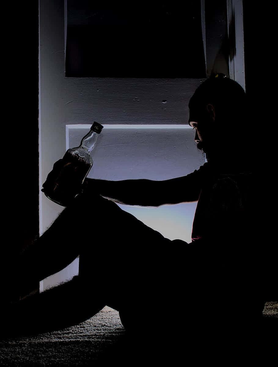 Silhouetteof Manwith Bottle Wallpaper