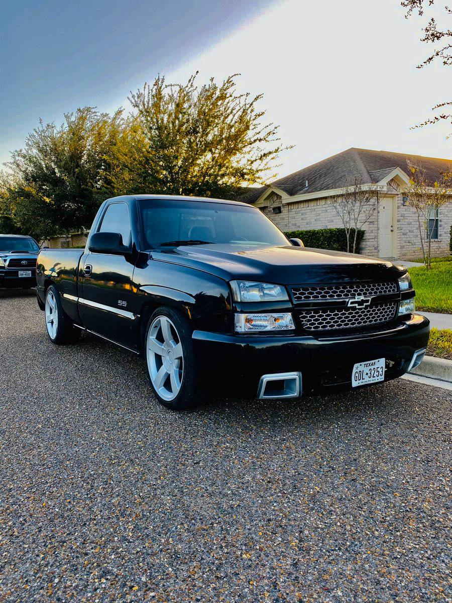 Sleek Black Dropped Truck Parked In A Neighborhood Wallpaper