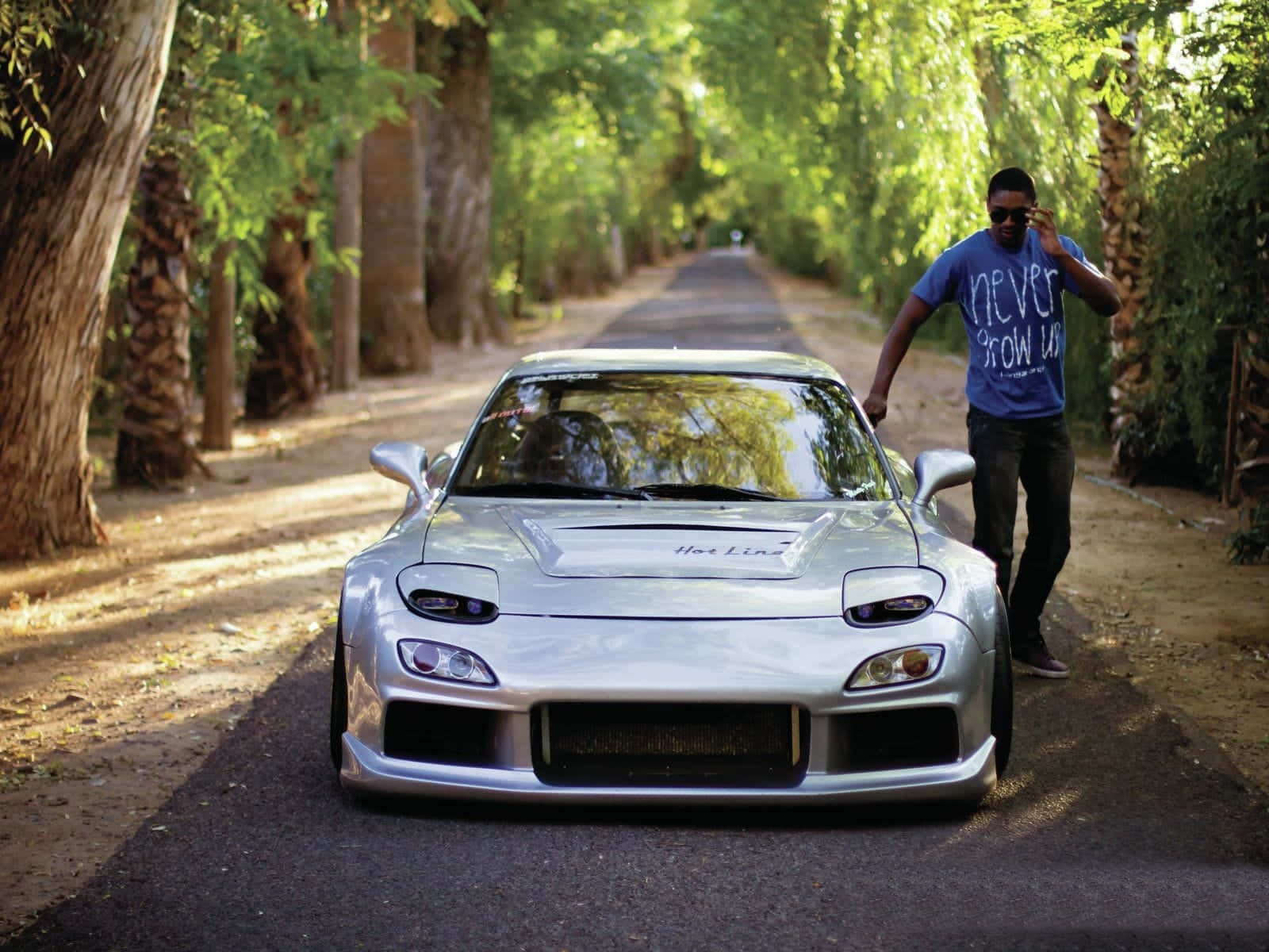 Sleek Silver Mazda Rx-7 Amidst Greenery Wallpaper