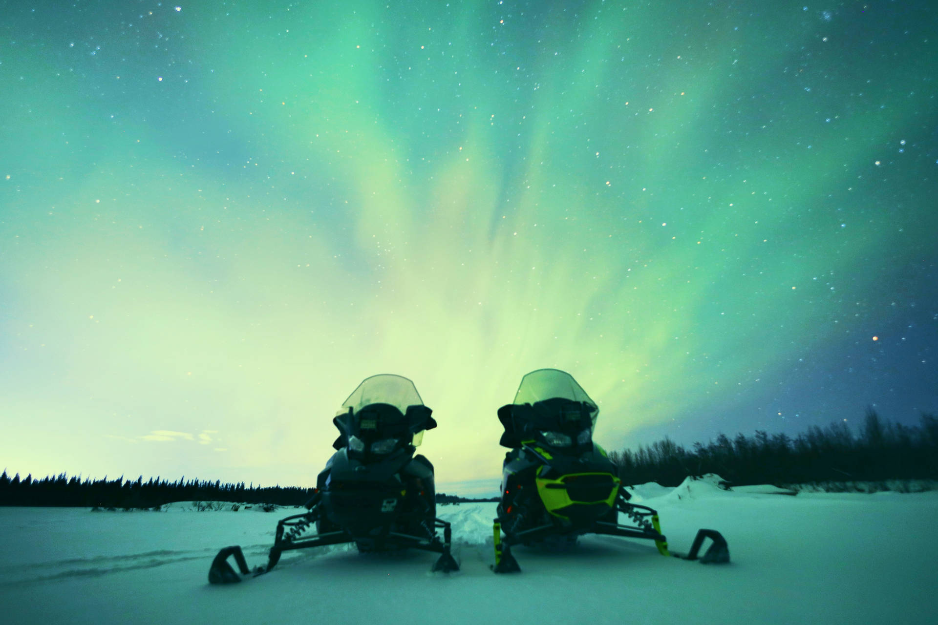 Snowmobiles Under Cool Winter Northern Lights Wallpaper