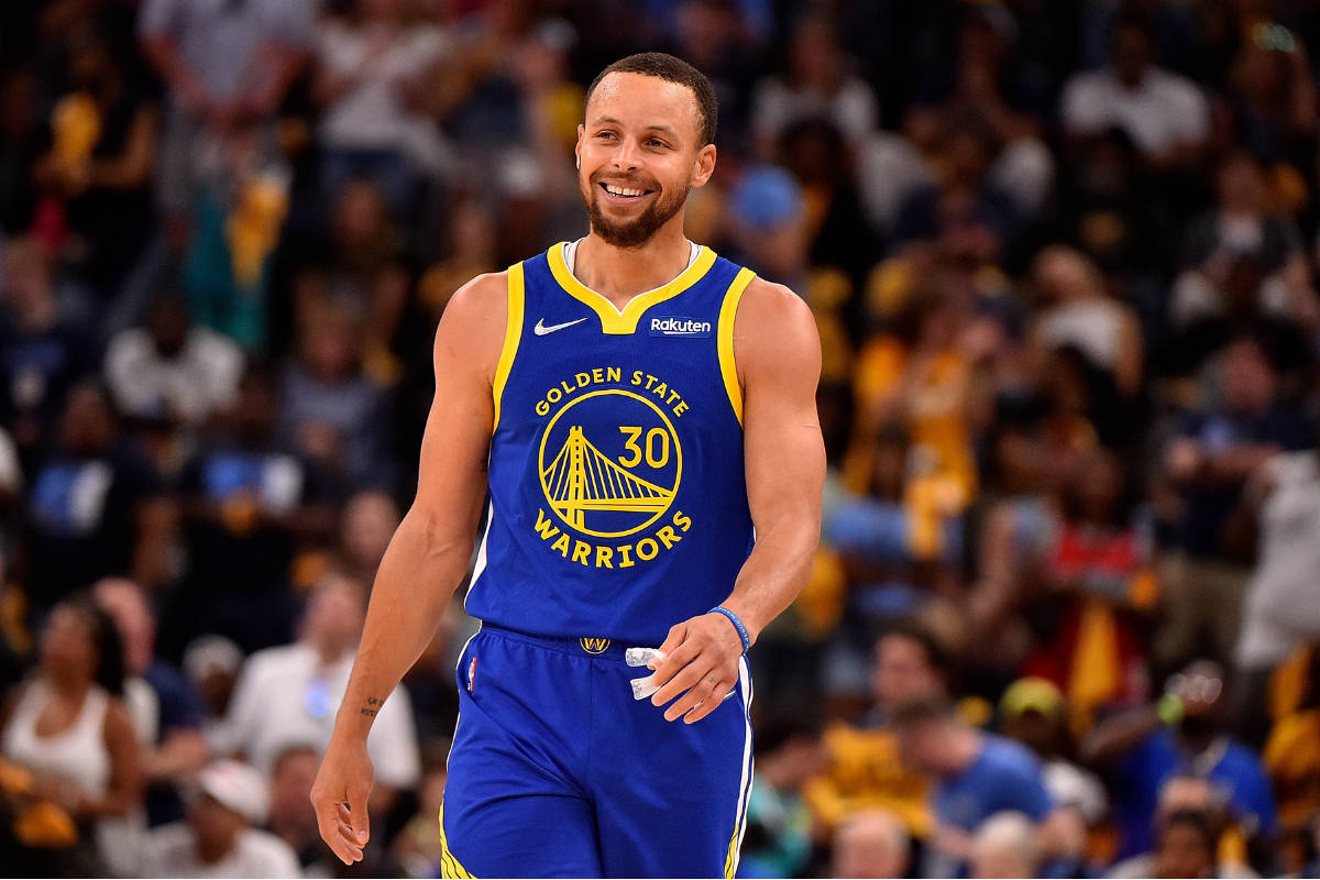 Steph Curry Smiling Against Blurry Crowd Wallpaper
