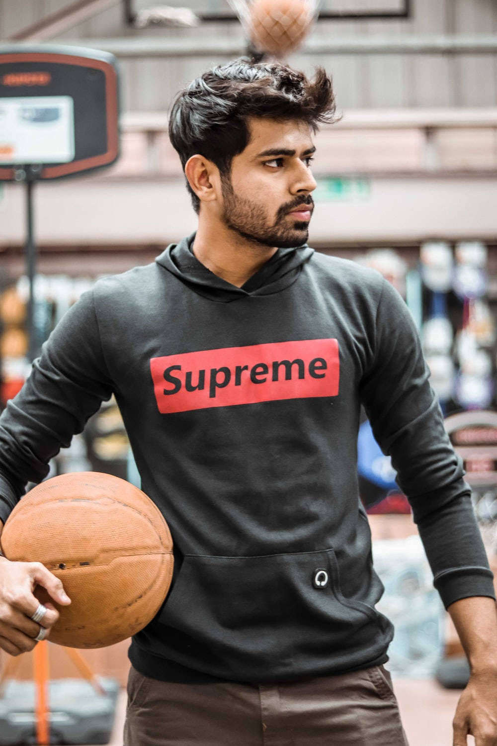 Stylish Player In Supreme Hoodie Holding Basketball Wallpaper