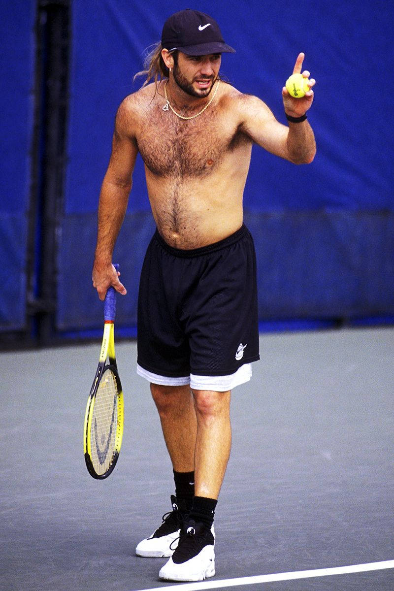 Tennis Legend Andre Agassi Posing Shirtless With A Black Cap Wallpaper