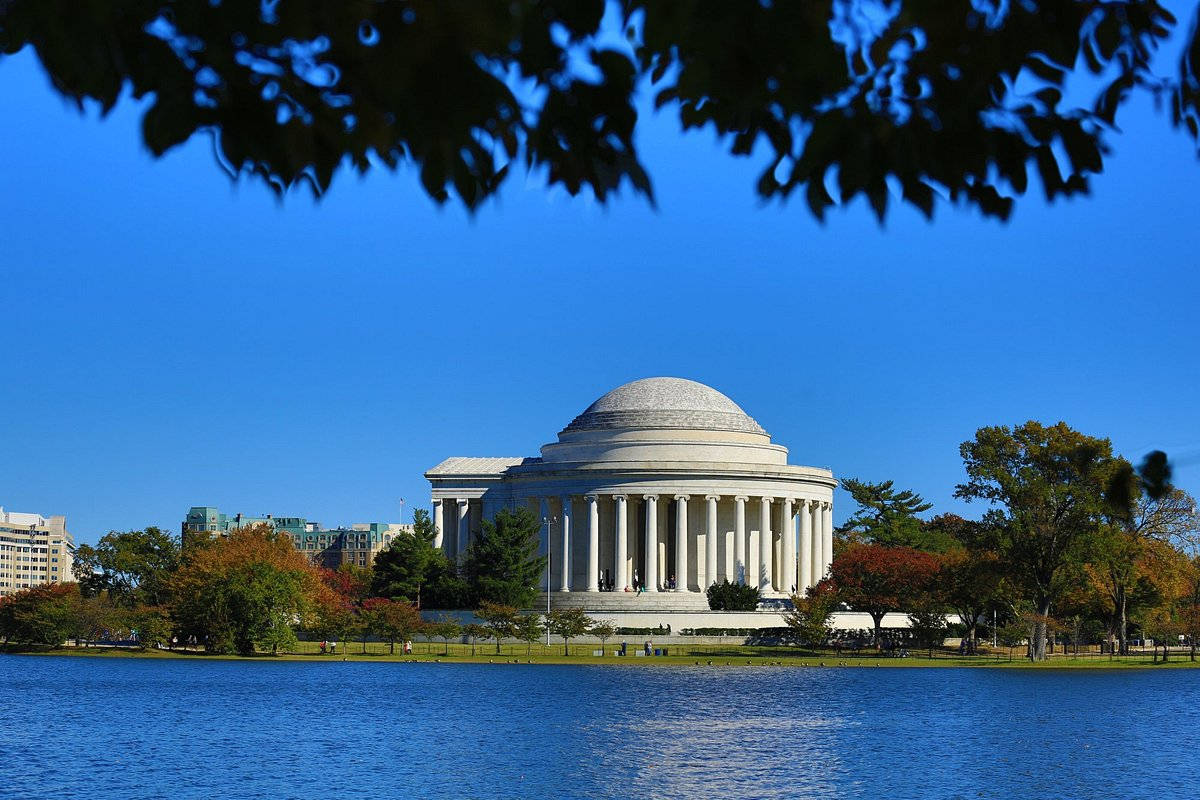 The Jefferson Memorial Standing Majestic Against The Blue Sky And Shimmering River Wallpaper