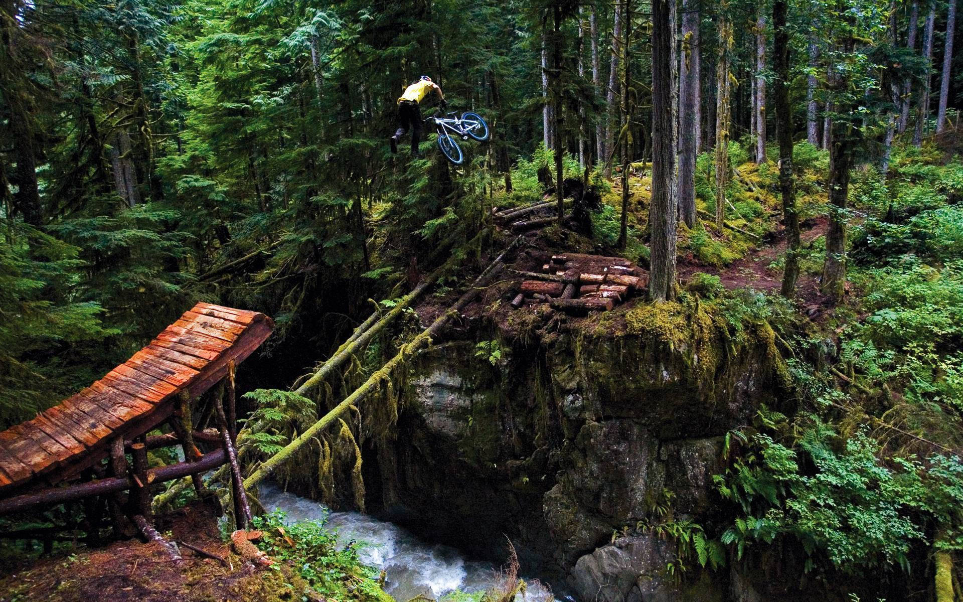 Thrilling Mtb Stunt Over A Long Jump Bridge Wallpaper