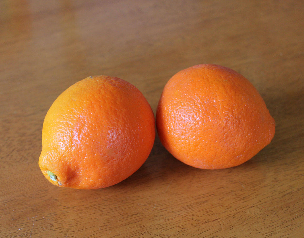 Two Tangelo Fruits On Wooden Table Wallpaper