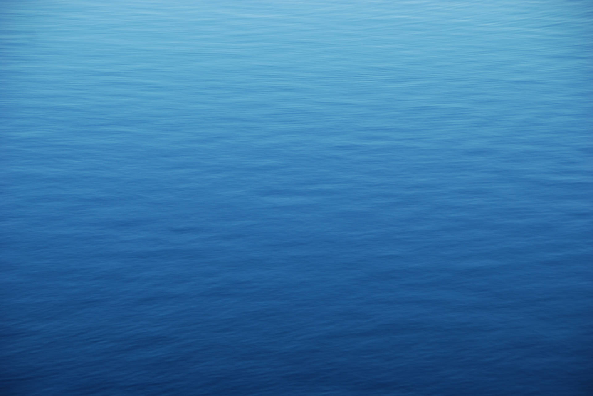 View From Above Of The Calm Blue Ocean Water Wallpaper