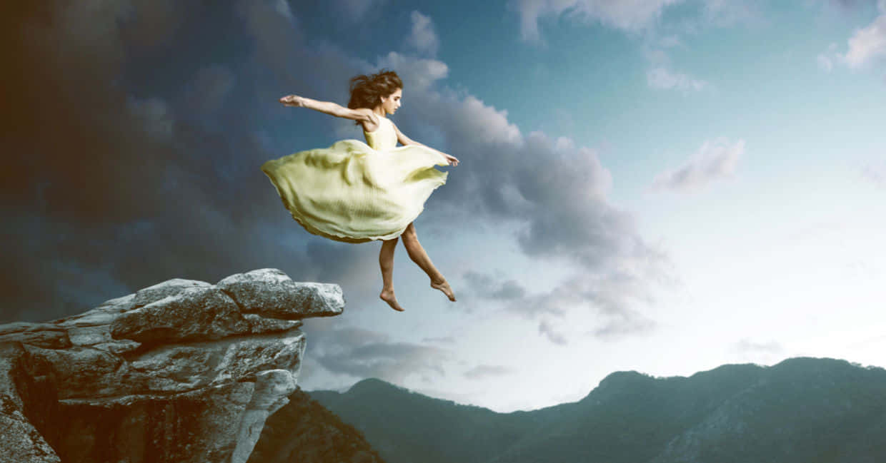 Woman Levitating Over Mountain Cliff Wallpaper