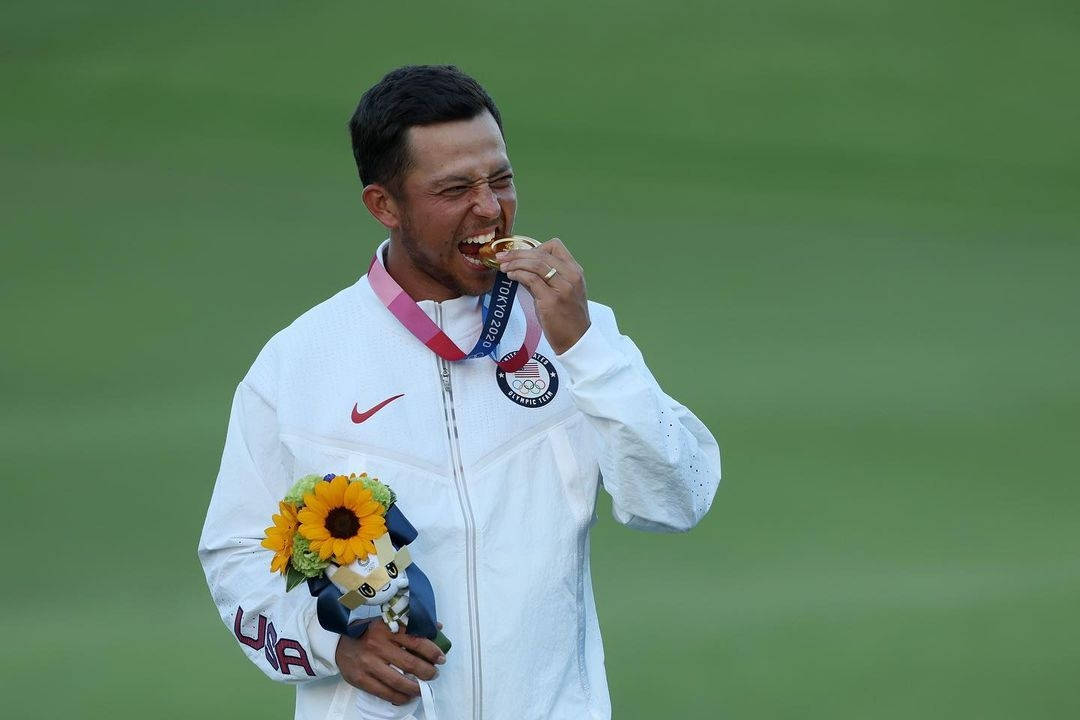 Xander Schauffele Biting A Medal Wallpaper