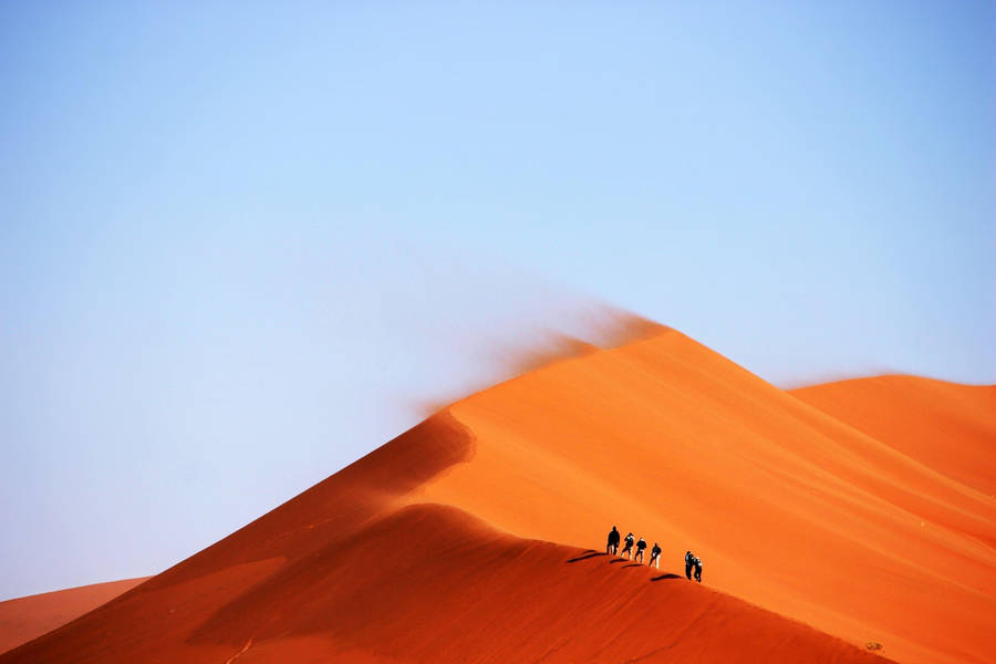 1) A Group Of People Seeking Adventure, Braving The Elements In A Windy Desert! Wallpaper