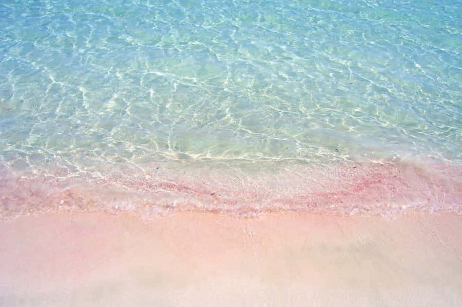 A Beach With Pink Sand And Water Wallpaper