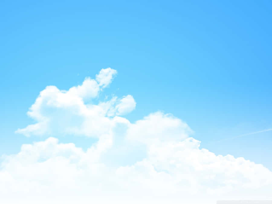 A Blue Sky With Clouds And A Plane Flying Over It Wallpaper