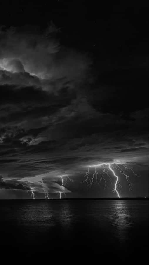 A Bolt Of Electric Blue Lightning Piercing A Night Sky. Wallpaper