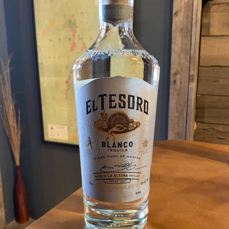 A Bottle Of Premium El Tesoro Blanco Tequila Elegantly Displayed On A Rustic Wooden Table. Wallpaper