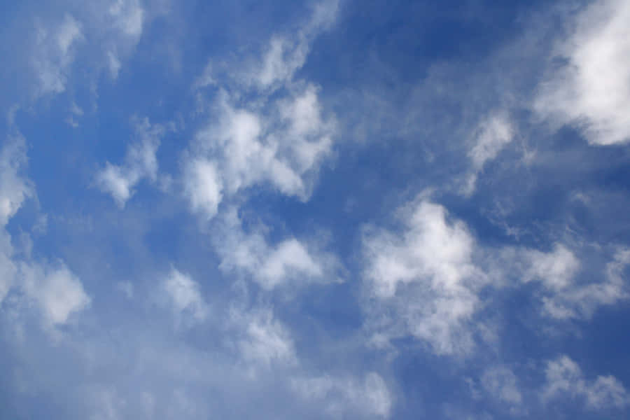 A Bright Blue Sky, Scattered With Cottony Clouds Wallpaper