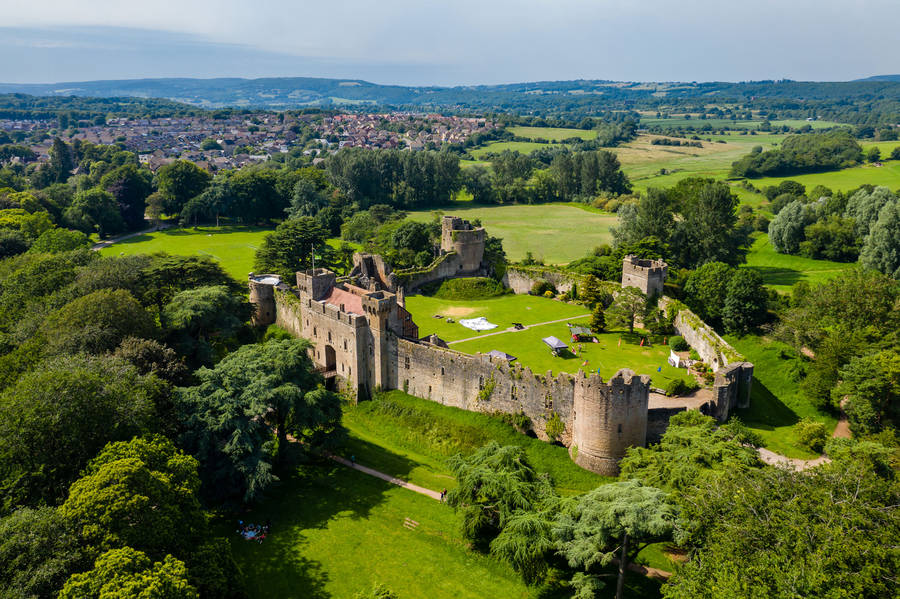 A Castle In The Middle Of A Green Field Wallpaper