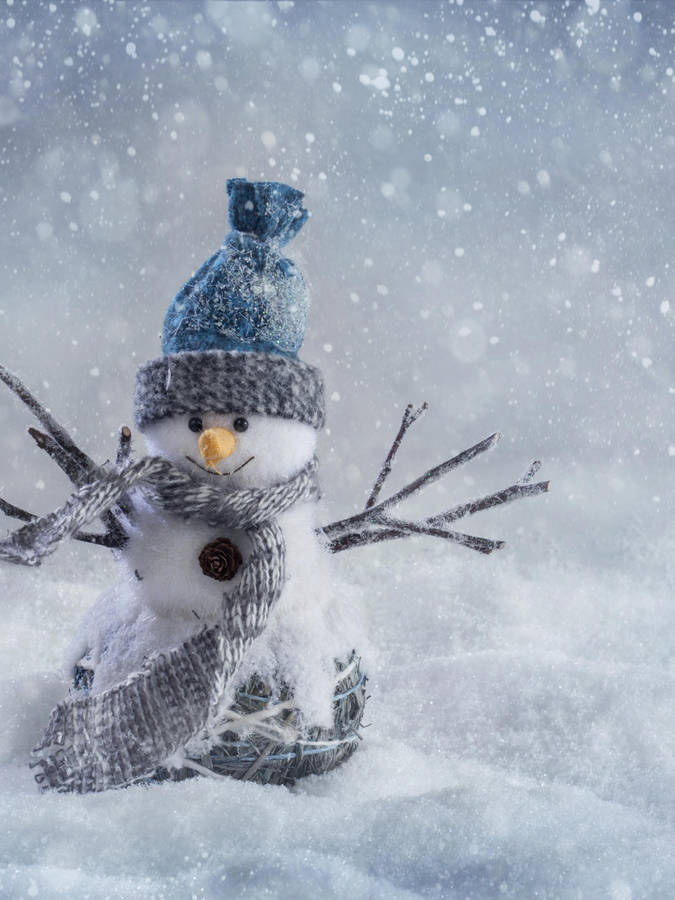 A Charming Winter Scene With A Little Snowman On An Iphone Wallpaper