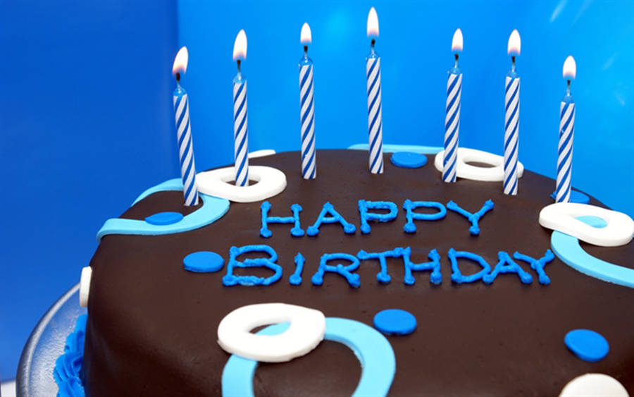 A Chocolate Birthday Cake With Sky-blue Candles Wallpaper