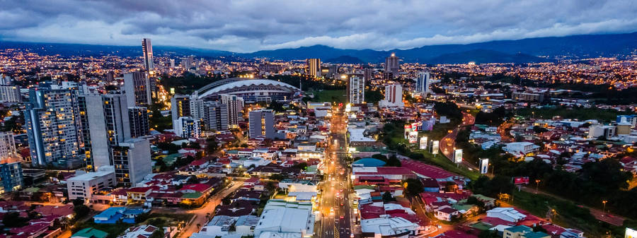 A City At Night With A Mountain In The Background Wallpaper