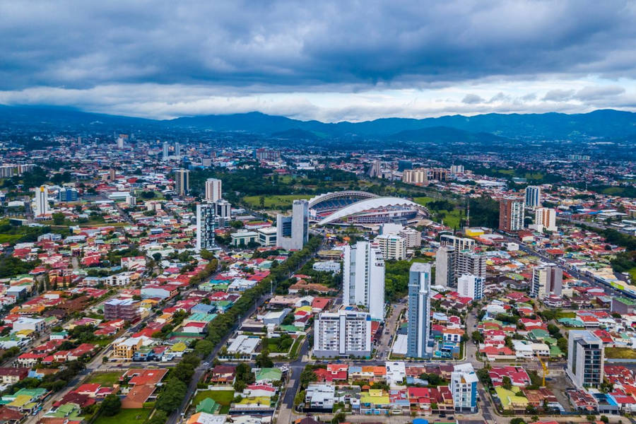 A City With A Stadium And Mountains In The Background Wallpaper