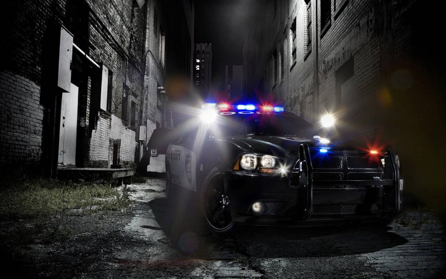 A Dedicated Police Officer Next To His Patrol Car Wallpaper