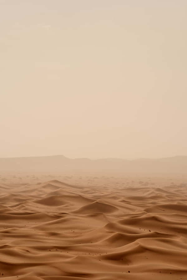 A Desert Landscape With Sand And Mountains Wallpaper