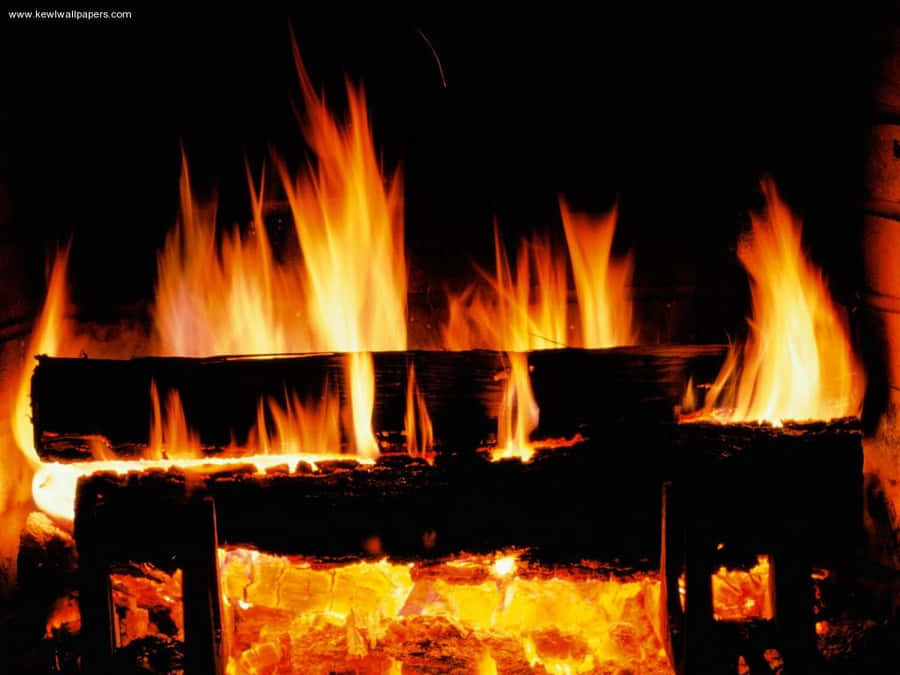 A Fireplace With Logs And Fire In It Wallpaper