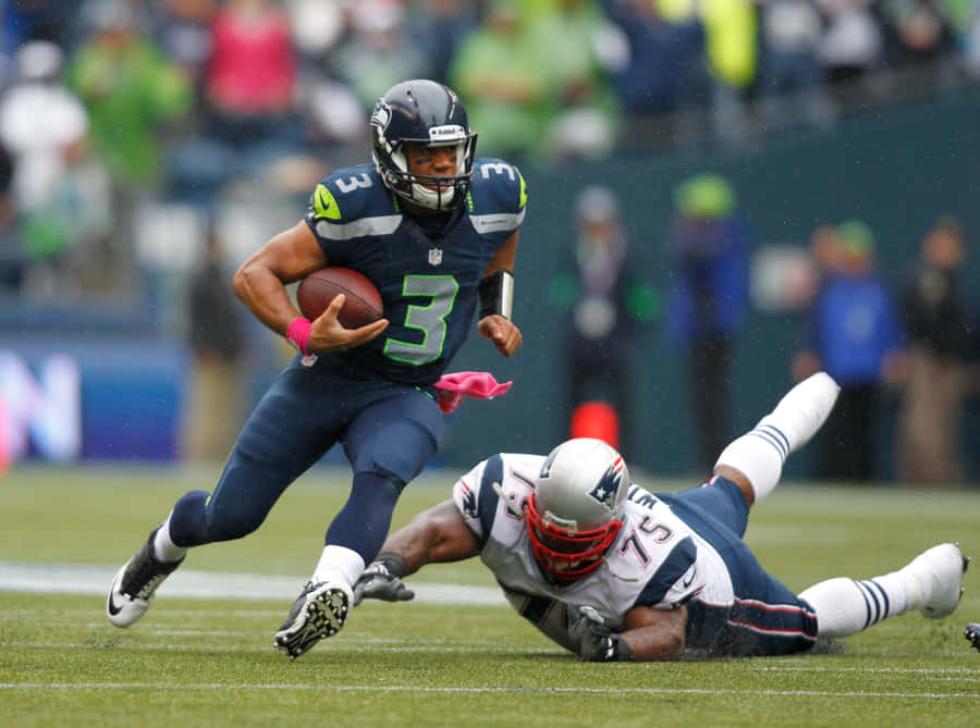 A Football Player Is Running With The Ball Wallpaper