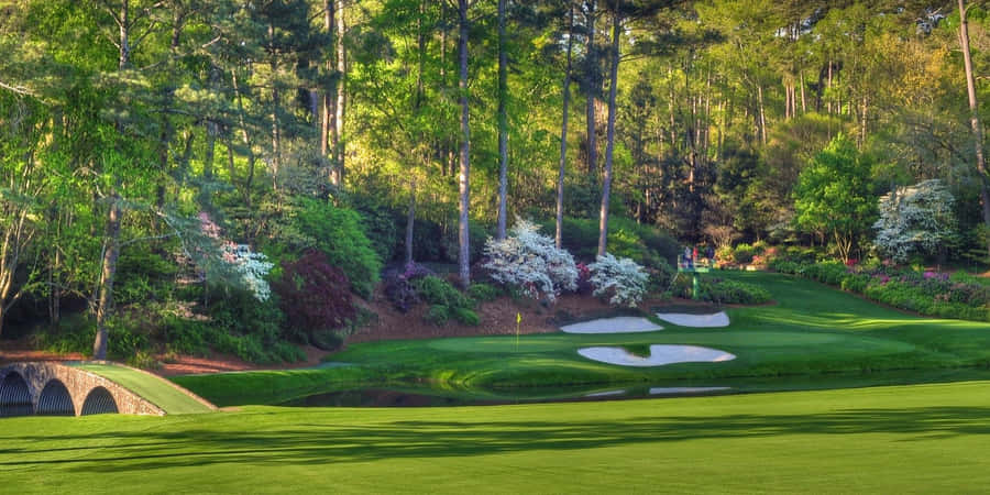 A Golf Course With A Bridge And Trees Wallpaper