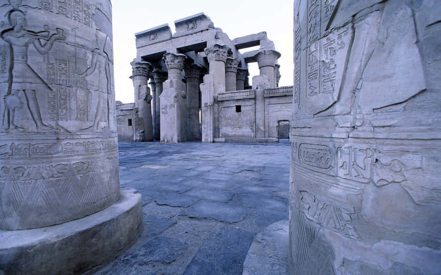 A Group Of Columns With Carvings In Them Wallpaper