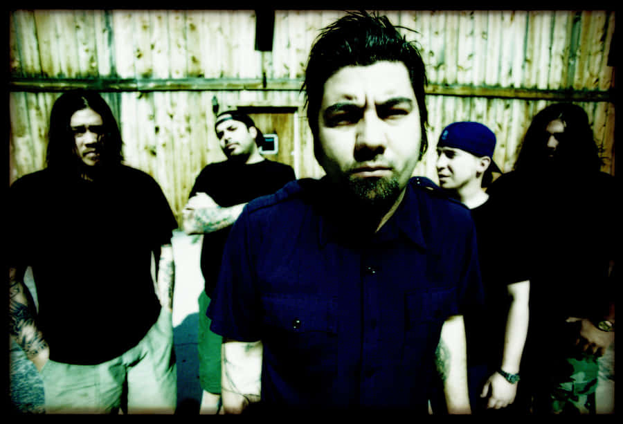 A Group Of Men Standing In Front Of A Wooden Building Wallpaper