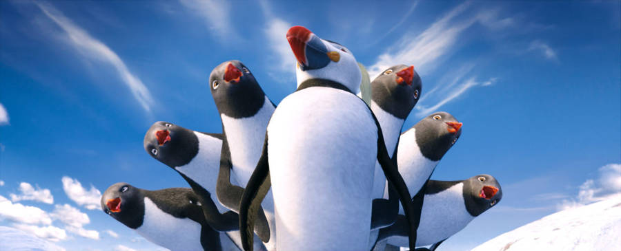 A Group Of Penguins Standing In The Snow Wallpaper