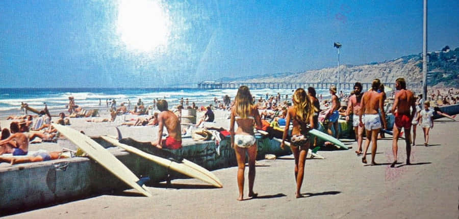 A Group Of People Walking Along The Beach Wallpaper
