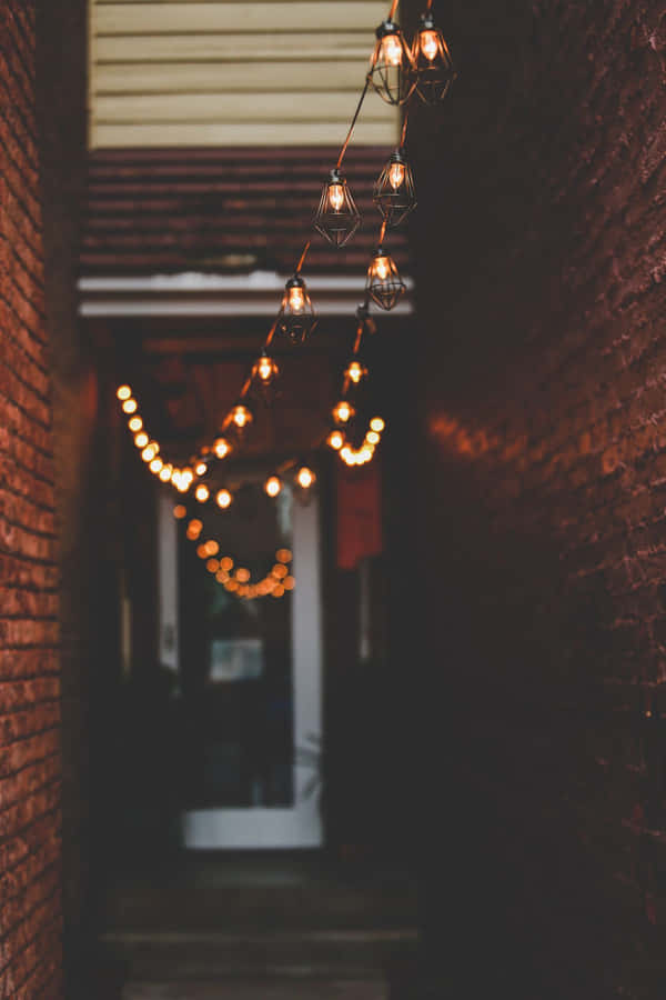 A Hallway With String Lights Hanging From The Ceiling Wallpaper